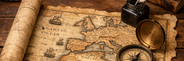 Open journal with quill and maps in lamplight